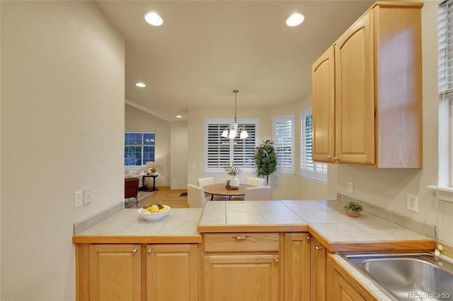 kitchen with a notable chandelier, decorative light fixtures, tile counters, and light brown cabinets