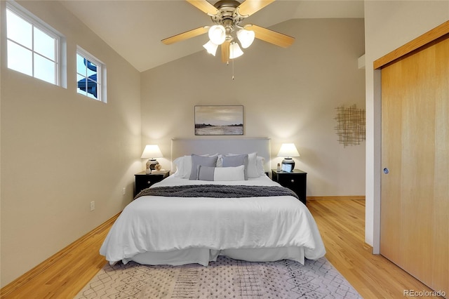 bedroom with ceiling fan, lofted ceiling, and light hardwood / wood-style floors