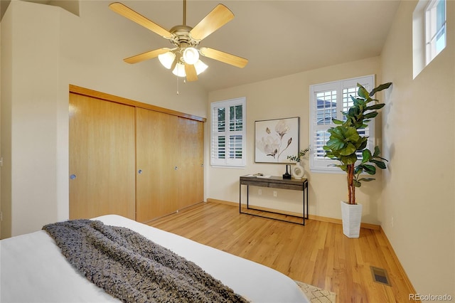 bedroom with ceiling fan, a closet, and light wood-type flooring