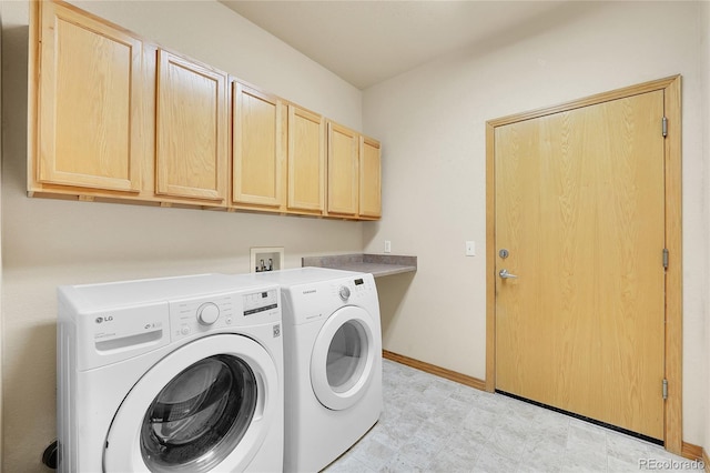 washroom featuring cabinets and washing machine and clothes dryer