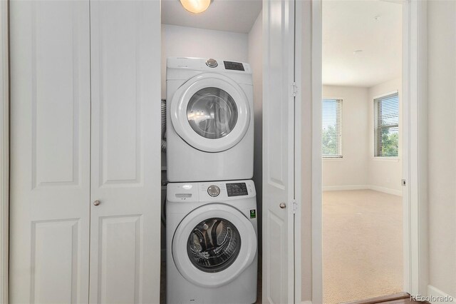 301 Inverness Way S Unit 202, Englewood, CO 80112 - laundry room with stacked washer and clothes dryer, carpet floors, and baseboards