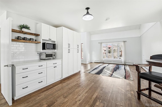 kitchen featuring open shelves, light countertops, decorative backsplash, wood finished floors, and built in microwave