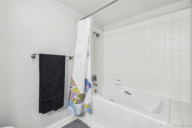 full bathroom with tiled shower / bath combo and tile patterned flooring