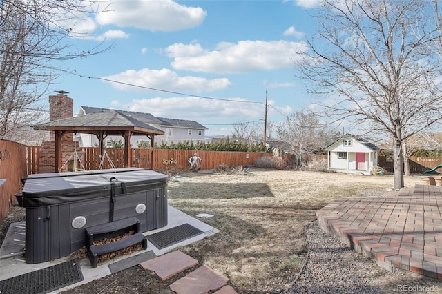 view of yard with an outbuilding, a patio, a fenced backyard, a gazebo, and a hot tub