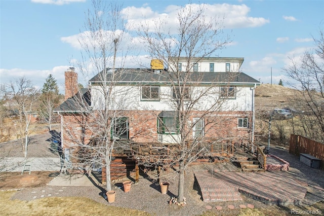 exterior space with brick siding and a chimney