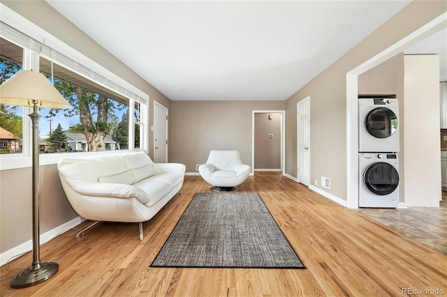 5142 S Pennsylvania St, Littleton, CO 80121 - sitting room featuring stacked washing machine and dryer, baseboards, and wood finished floors