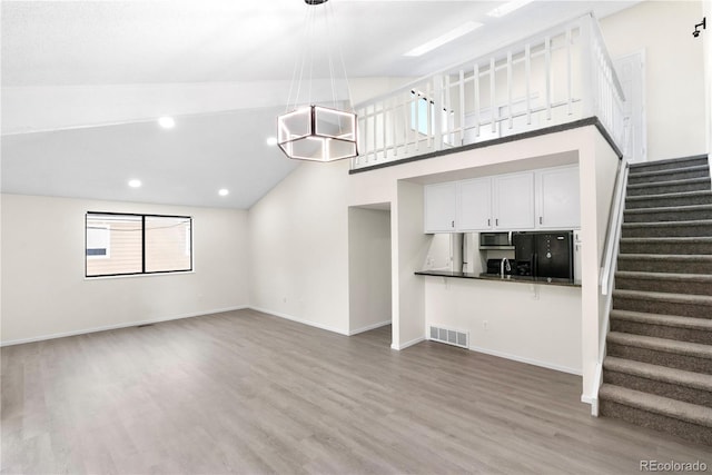1732 S Trenton Unit 9, Denver, CO 80231 - unfurnished living room with stairs, wood finished floors, recessed lighting, and high vaulted ceiling