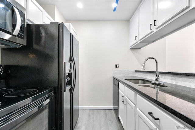 1732 S Trenton Unit 9, Denver, CO 80231 - kitchen with black appliances, dark stone counters, light wood-style floors, white cabinets, and recessed lighting