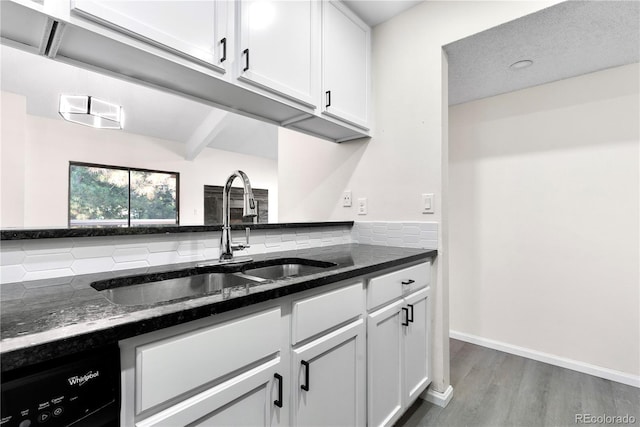 1732 S Trenton Unit 9, Denver, CO 80231 - kitchen featuring wood finished floors, tasteful backsplash, white cabinets, dark stone countertops, and dishwashing machine