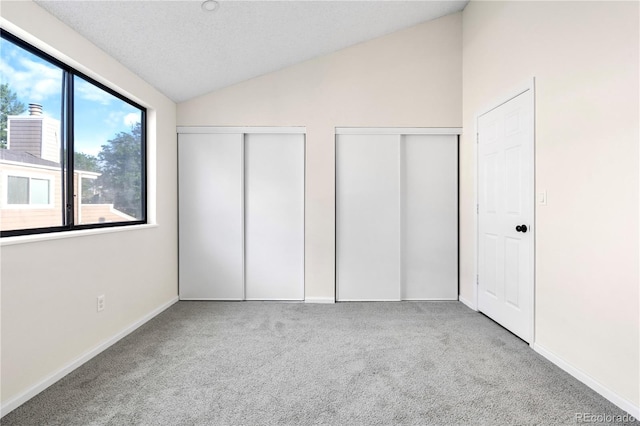 1732 S Trenton Unit 9, Denver, CO 80231 - unfurnished bedroom with two closets, carpet flooring, and lofted ceiling