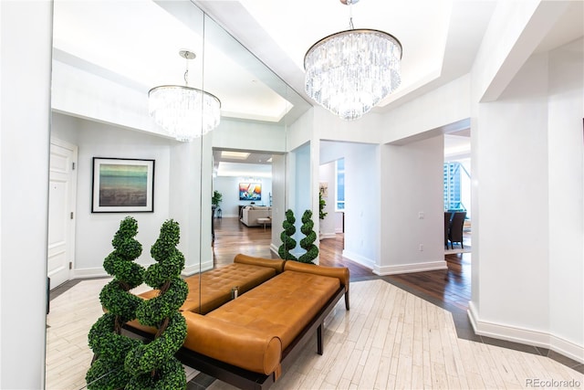 interior space featuring hardwood / wood-style flooring, a raised ceiling, and an inviting chandelier