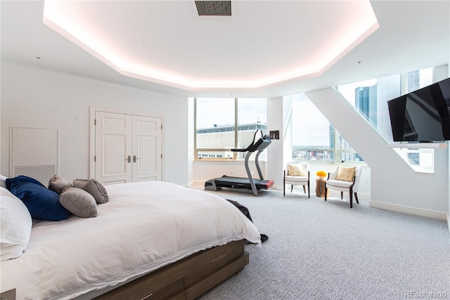 bedroom featuring a closet, carpet, and a tray ceiling