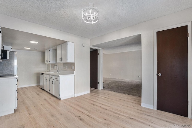 kitchen with light hardwood / wood-style floors, white cabinetry, and sink