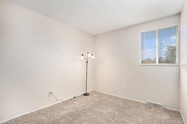 carpeted spare room featuring a textured ceiling