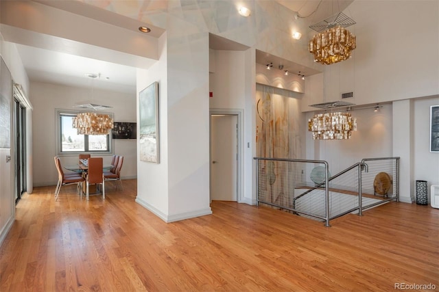 180 N Cook St Unit 509, Denver, CO 80206 - corridor featuring a chandelier, an upstairs landing, wood finished floors, baseboards, and a towering ceiling