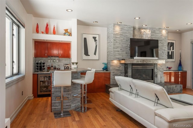 180 N Cook St Unit 509, Denver, CO 80206 - indoor wet bar with beverage cooler, light wood-type flooring, healthy amount of natural light, a fireplace, and recessed lighting