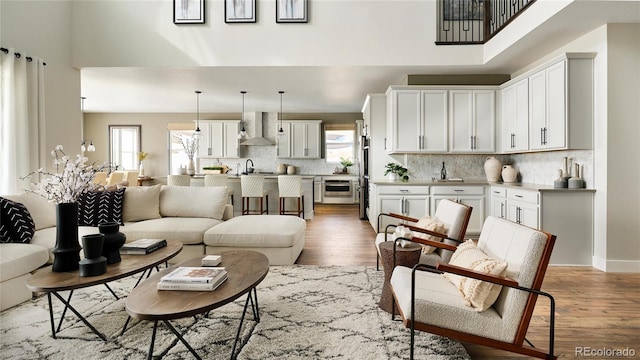 living room featuring a towering ceiling, plenty of natural light, and hardwood / wood-style floors