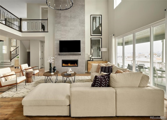 living room featuring hardwood / wood-style floors, a fireplace, and a towering ceiling