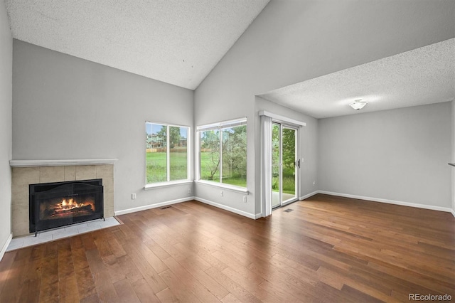 10349 W Fair Ave Unit A, Littleton, CO 80127 - unfurnished living room featuring a fireplace, high vaulted ceiling, wood-type flooring, baseboards, and a textured ceiling