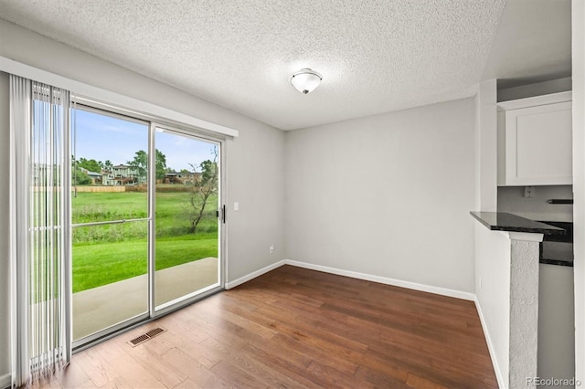 10349 W Fair Ave Unit A, Littleton, CO 80127 - unfurnished dining area with wood finished floors, a textured ceiling, and baseboards
