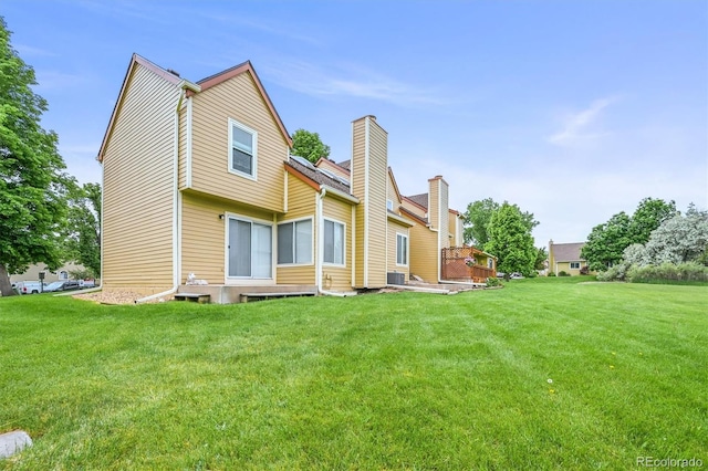 10349 W Fair Ave Unit A, Littleton, CO 80127 - rear view of house featuring a lawn, central air condition unit, and a chimney