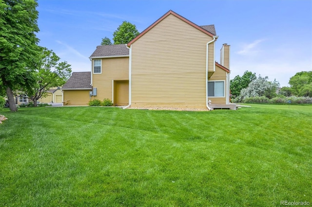 10349 W Fair Ave Unit A, Littleton, CO 80127 - back of property featuring a chimney, a yard, and roof with shingles