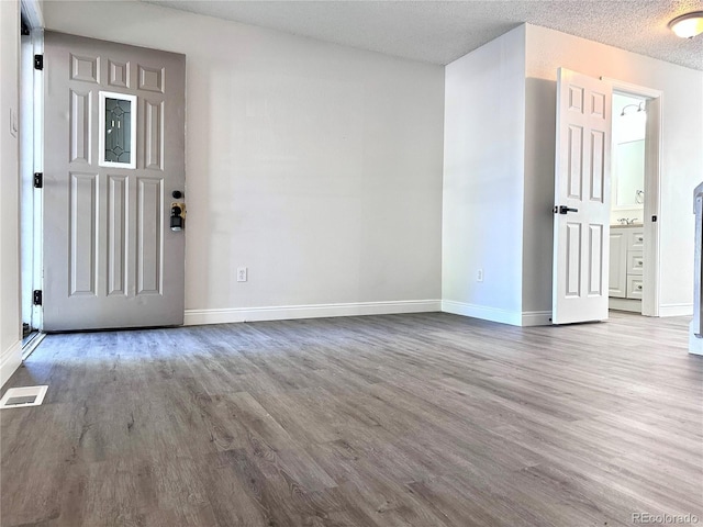 empty room featuring light hardwood / wood-style floors and a textured ceiling