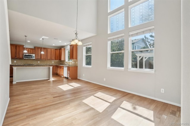 13075 Tamarac St, Thornton, CO 80602 - kitchen with stainless steel microwave, dishwasher, plenty of natural light, open floor plan, and recessed lighting