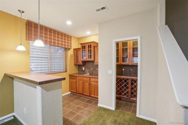 13075 Tamarac St, Thornton, CO 80602 - kitchen featuring brown cabinets, glass insert cabinets, dark tile patterned flooring, pendant lighting, and recessed lighting