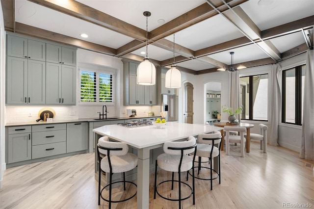 852 Pontiac St, Denver, CO 80220 - kitchen with gray cabinets, light wood finished floors, arched walkways, a kitchen breakfast bar, and stainless steel appliances