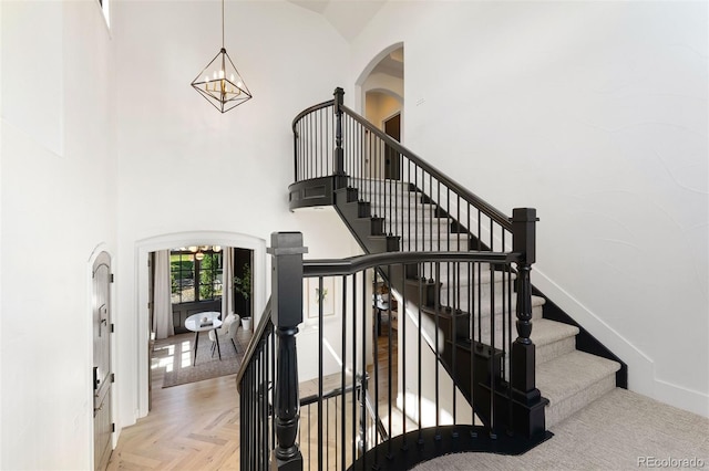 852 Pontiac St, Denver, CO 80220 - stairs featuring arched walkways, a chandelier, and a high ceiling