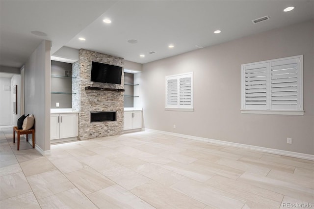 852 Pontiac St, Denver, CO 80220 - unfurnished living room featuring built in shelves, recessed lighting, and a stone fireplace