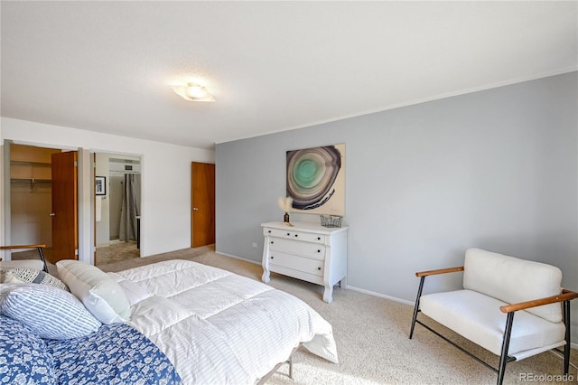 bedroom featuring light colored carpet, baseboards, and a spacious closet