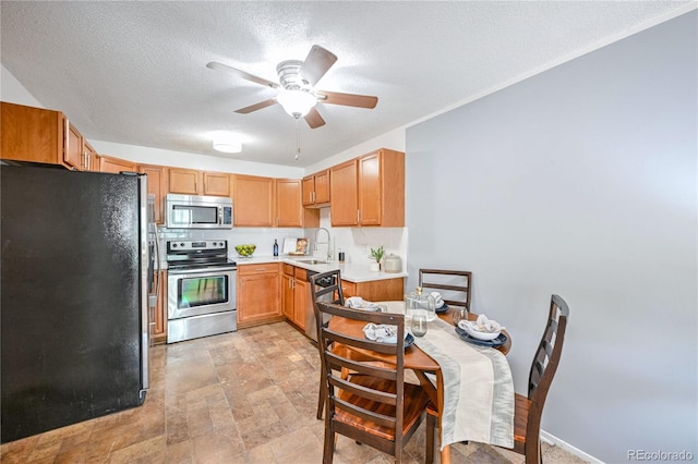 kitchen featuring sink, ceiling fan, appliances with stainless steel finishes, and a textured ceiling