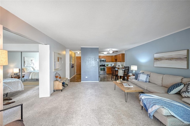 carpeted living room with a textured ceiling and ceiling fan