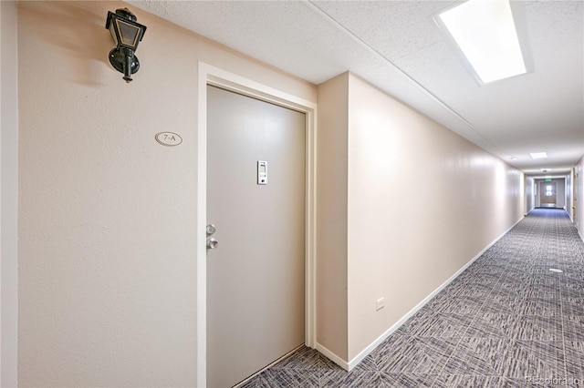 corridor with baseboards and carpet
