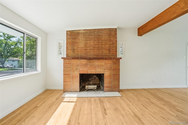 6155 Carr St, Arvada, CO 80004 - unfurnished living room featuring wood finished floors, a brick fireplace, and baseboards