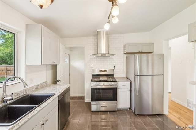 6155 Carr St, Arvada, CO 80004 - kitchen featuring appliances with stainless steel finishes, a sink, exhaust hood, backsplash, and dark wood-style flooring