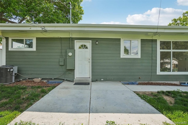 6155 Carr St, Arvada, CO 80004 - doorway to property featuring central AC unit and a patio