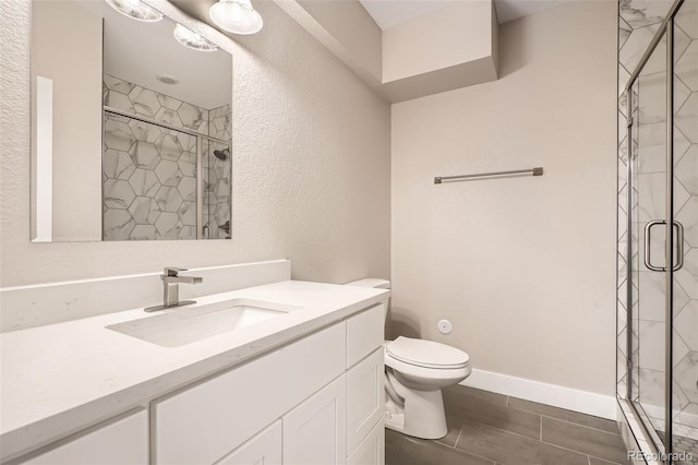 bathroom featuring an enclosed shower, vanity, and toilet