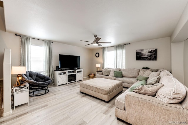 living room featuring ceiling fan, light wood-type flooring, and plenty of natural light