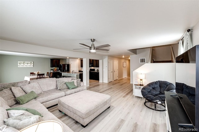 living room with ceiling fan and light wood-type flooring