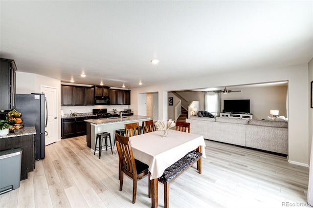 dining space featuring ceiling fan, light hardwood / wood-style floors, and sink