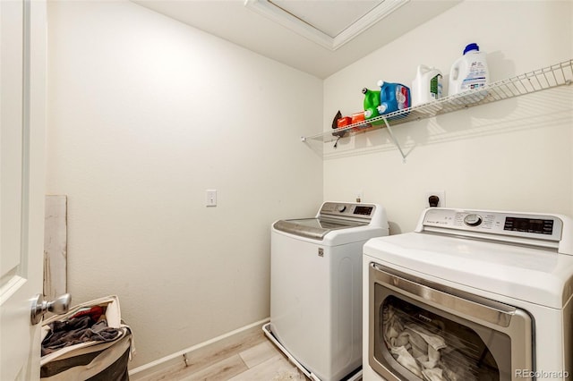 laundry room featuring washer and dryer and light hardwood / wood-style floors