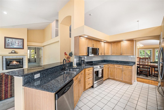 1010 Home Farm Cir, Denver, CO 80234 - kitchen featuring appliances with stainless steel finishes, arched walkways, a peninsula, light tile patterned floors, and healthy amount of natural light