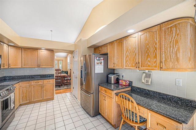 1010 Home Farm Cir, Denver, CO 80234 - kitchen with appliances with stainless steel finishes, lofted ceiling, light tile patterned floors, arched walkways, and tasteful backsplash