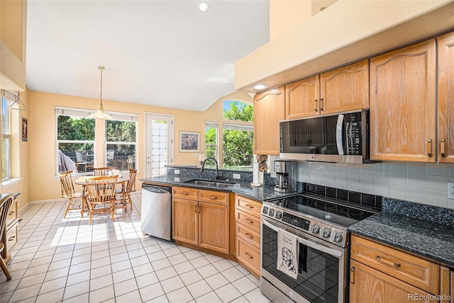 1010 Home Farm Cir, Denver, CO 80234 - kitchen with stainless steel appliances, vaulted ceiling, light tile patterned floors, backsplash, and hanging light fixtures