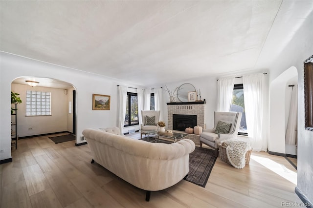 living room featuring a wealth of natural light, a fireplace, and light hardwood / wood-style floors