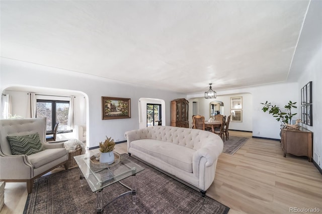 living room with light hardwood / wood-style flooring and a notable chandelier