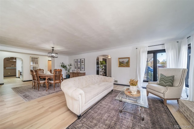 living room featuring a chandelier and light wood-type flooring